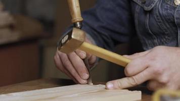 Wood worker cuts out a dovetail on a pine board