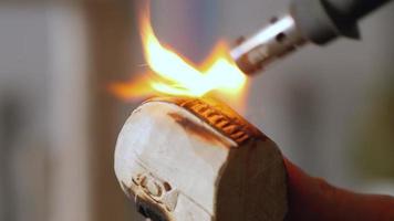 artesano quema un trozo de madera