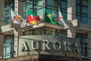 Bento Goncalves, Brazil - July 11, 2019. Company signboard and flags on the facade of Aurora Winery building at Bento Goncalves. A friendly country town famous for its wine production. photo