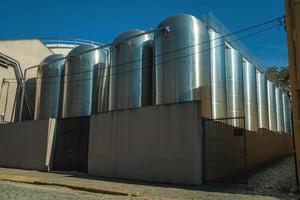 Bento Goncalves, Brazil - July 11, 2019. Stainless steel storage tanks for grape juice or wine at Aurora Winery in a street of Bento Goncalves. A friendly country town famous for its wine production. photo