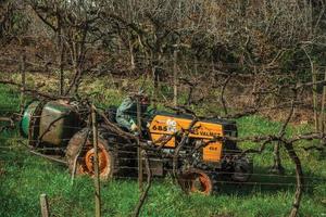 Bento Goncalves, Brazil - July 12, 2019. Landscape with a farmer on a tractor amid leafless grapevines, in a vineyard near Bento Goncalves. A friendly country town famous for its wine production. photo