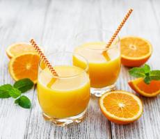 vasos de jugo y frutas de naranja