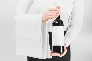 waiter holding offering bottle wine photo