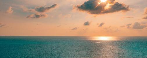 Aerial panoramic view of sunset over ocean. Colorful sky, clouds and water. Amazing serene scenic photo