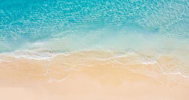 Relaxing aerial beach scene, summer vacation holiday template banner. Waves surf with amazing blue ocean lagoon, sea shore, coastline. Perfect aerial drone top view. Peaceful bright beach, seaside photo