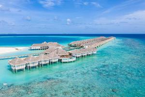 Perfect aerial landscape, luxury tropical resort or hotel with water villas and beautiful beach scenery. Amazing bird eyes view in Maldives, landscape seascape aerial view over a Maldives photo