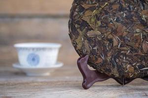 natural Chinese white tea in the form of a pancake. pressed round tea on a wooden stand photo