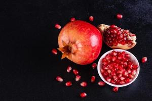 Tasty fresh red pomegranate on a dark concrete background