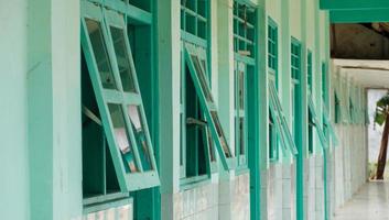 a school corridor with wooden windows on the side photo