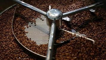 tostador de café refrescarse los granos de café tostados frescos lote de granos en la máquina cilíndrica. metraje 4k de alta calidad