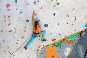 A man is climbing a climbing wall photo