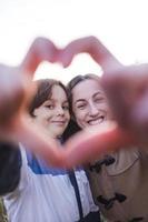 Boy with mom folded fingers in the shape of a heart. photo