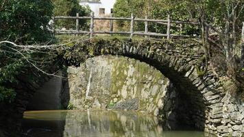 The old arched stone bridge made many years ago in the countryside of the China photo