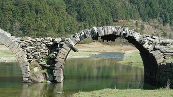 El viejo puente arqueado de piedra hecho hace muchos años en el campo de China. foto