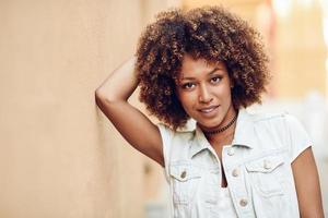 Young black woman, afro hairstyle, smiling in urban background photo