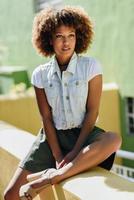 Black woman, afro hairstyle, wearing casual clothes in urban background photo