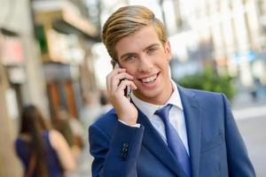 Attractive young businessman in urban background photo