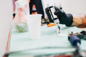 Female tattooist preparing the dyes she's going to work with. photo