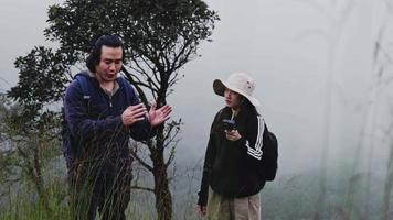 casais de blogueiros de turistas asiáticos usando a câmera de ação para registrar a viagem e falando sobre atrações turísticas nas montanhas. viagem ao ar livre e tema da natureza. video