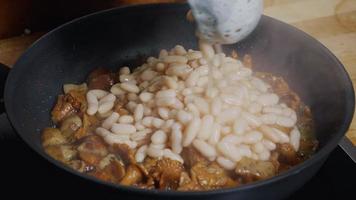 Adding white beans in pan. video