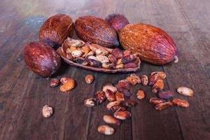 Dried cocoa fruit and dried cocoa beans on old wooden background photo