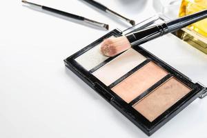 Cosmetics with face brush on white background photo