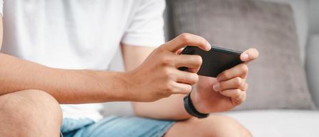 Closeup of happy man using a smartphone, searching, browsing, social media, message, email, play game, internet digital marketing, online shopping. photo