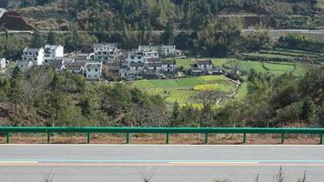 La hermosa carretera rural cruza las montañas y el pueblo en el campo de China. foto