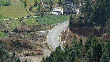 La hermosa carretera rural cruza las montañas y el pueblo en el campo de China. foto