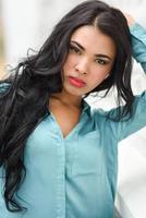 Hispanic young woman wearing casual clothes in urban background photo