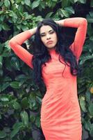 Woman wearing orange dress in an urban park photo