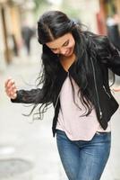 Hispanic young woman wearing casual clothes in urban background photo