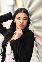 Hispanic young woman wearing casual clothes in urban background photo