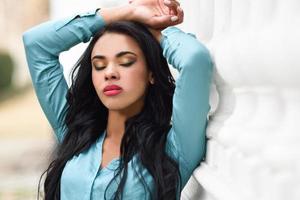 Hispanic young woman wearing casual clothes in urban background photo