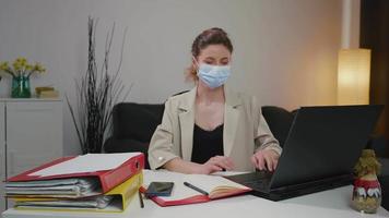 mulher de negócios doente espirros enquanto trabalhava no escritório em casa com máscara.