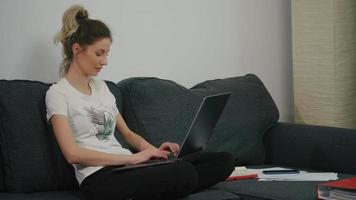Focused woman developing new project while working on laptop at home.