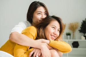 Beautiful young asian women LGBT lesbian happy couple sitting on bed hugging and smiling together in bedroom at home. LGBT lesbian couple together indoors concept. Spending nice time at home. photo