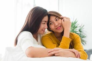 Beautiful young asian women LGBT lesbian happy couple sitting on bed hugging and smiling together in bedroom at home. LGBT lesbian couple together indoors concept. Spending nice time at home. photo