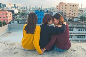 Happy group of asia girl friends enjoy and arm up relax pose at roof top party at evening sunset,Holiday celebration festive,teenage lifestyle,freedom and fun photo