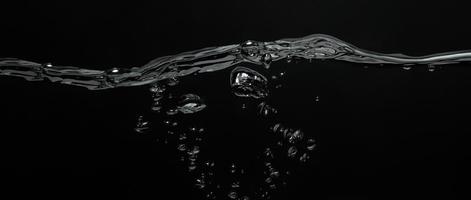 Close up soda water bubbles floating up to top of water surface. photo