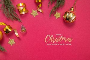 Merry Christmas inscription on red background with decorative elements and green branches flat lay