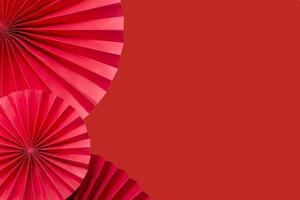 Red paper fans on a red monochrome background copy space. photo