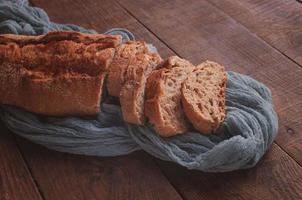 rebanadas de pan sobre una mesa de madera con un mantel de gasa gris foto