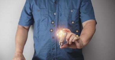 hombre sosteniendo una bombilla conceptos de tecnología, marketing, comunicación que pueden suceder todo el tiempo. foto