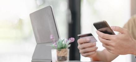 Online payment, Man's hands holding a credit card and using smartphone and choose some product what him want for online shopping. photo