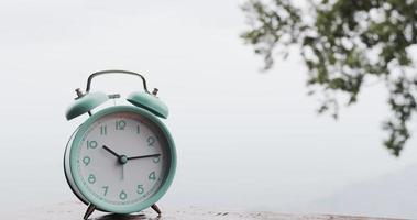 lapso de tiempo, el reloj de alarma azul muestra el correr del tiempo. con buen tiempo. Fondo al aire libre. video