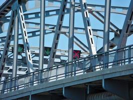 Iron bridges across the river and traffic lights red green arrows on the floor fresh blue sky photo