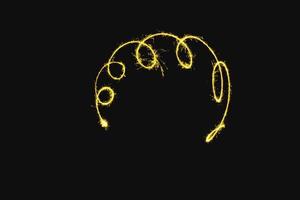 abstract curve gold yellow sparkler overlays texture elegant surface pattern on black. photo