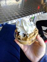 patrón de postre helado de sabor helado en taza blanca mano sujetando sobre la mesa. foto