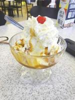 patrón de postre helado de sabor helado en taza blanca mano sujetando sobre la mesa. foto